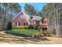 Beautiful two-story brick home with a manicured front yard and mature trees at 5327 Saville Nw Dr, Acworth, GA 30101