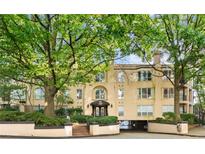 A tan three-story building featuring a brick entrance and trimmed by mature trees at 209 14Th Ne St # 109, Atlanta, GA 30309