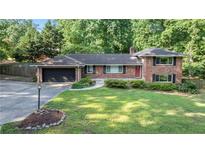 Charming brick home featuring a two-car garage and a lush, green front yard at 23 Hunting Creek Dr, Marietta, GA 30068