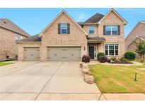 Charming brick home featuring a three-car garage and professionally landscaped front yard at 4708 Tiger Blvd, Duluth, GA 30096
