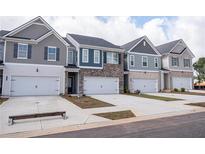 Charming new construction townhomes featuring varied color schemes and attached garages at 6003 Pine Bluff Pl, Conyers, GA 30013