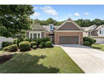 Charming home with a brick facade, manicured landscaping, and a two-car garage at 1955 Overlook Run Pl, Cumming, GA 30040
