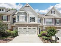 Charming townhome with a two-car garage, manicured landscaping, and a welcoming facade at 2910 Cross Creek Dr, Cumming, GA 30040
