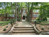 Charming brick building with a landscaped entrance and mature trees, offering a warm and inviting welcome at 1031 State Nw St # 106, Atlanta, GA 30318