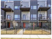Modern townhouse featuring balconies, metal accents, and a well-maintained front yard with fence at 1145 Kirkwood Se Ave # 14, Atlanta, GA 30316