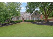 Charming brick home featuring a lush lawn and manicured landscaping, offering classic curb appeal at 415 Winn Park Ct, Roswell, GA 30075