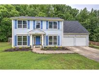 Charming two-story home featuring light blue siding, blue shutters, and a well-manicured lawn at 4975 Rockstone Way, Acworth, GA 30101