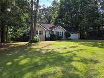 Charming single-story home with a well-maintained lawn, mature trees, and an attached two-car garage at 273 Apalachee Church Rd, Auburn, GA 30011