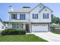 Charming two-story home with a well-manicured lawn and attached two-car garage on a sunny day at 504 Hillcrest Cross Rd, Canton, GA 30115