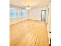 Bright living room featuring hardwood floors and neutral walls illuminated by stylish lighting at 2230 Peachtree Road Nw Rd # A4, Atlanta, GA 30309