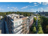 Modern apartment building boasts stunning architecture, complemented by a lush green landscape and clear blue skies at 675 Drewry Ne St # 205, Atlanta, GA 30306