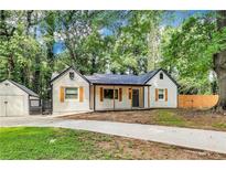 Charming home with wooden shutters and a spacious driveway surrounded by mature trees at 500 Pomoma Circle Sw, Atlanta, GA 30315