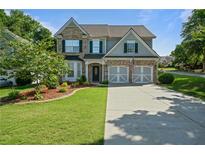 Charming two-story home with a well-manicured front lawn and a driveway leading to a two-car garage at 700 Mill Creek Cv, Canton, GA 30115
