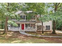 Charming two-story home featuring a welcoming front porch with a bright red door at 701 Robert Ln, Canton, GA 30114