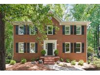 Charming two-story brick home features black shutters and a manicured front yard with mature trees at 2863 Landing Dr, Marietta, GA 30066