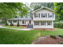 Charming two-story home with a well-maintained lawn and inviting curb appeal, surrounded by mature trees at 2786 Georgian Ter, Marietta, GA 30068
