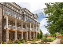 Beautiful townhome with brick and siding, a covered porch, a balcony, and mature landscaping at 410 Concord St, Alpharetta, GA 30009