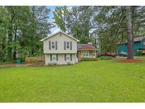 Charming home with a well-manicured lawn, complemented by lush trees and lovely landscaping at 5461 Forest Path Ct, Stone Mountain, GA 30088