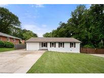 Charming single-story home with a well-manicured lawn and a driveway leading to an attached garage at 2021 Sherwood Dr Se, Marietta, GA 30062