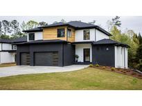 Modern two-story home with a black brick, white stucco, and natural wood exterior with a well-manicured lawn at 2551 Kilgore Rd, Buford, GA 30519