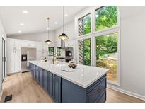 Bright kitchen boasts a large center island, stainless appliances, and floor-to-ceiling window views at 3430 Rocky Springs Ct, Marietta, GA 30062
