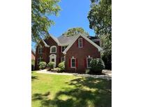 Traditional two-story brick home featuring red shutters and a well-manicured front lawn at 5190 Beech Forest Sw Dr, Lilburn, GA 30047