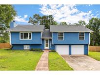Charming blue two-story home with a well-manicured lawn and a brick pathway leading to the front door at 319 Hill Crest Cir, Woodstock, GA 30188