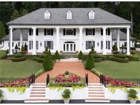 Stunning exterior elevation of a white home with black shutters and large column lined porch at 1822 Chartwell Trce, Stone Mountain, GA 30087