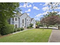 Charming two-story home with a well-manicured lawn, lush greenery, and beautiful landscaping at 3260 Kingshouse Commons, Johns Creek, GA 30022