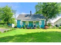 Charming blue home featuring a well-manicured lawn, lovely landscaping, and inviting front porch at 5150 Wheat Ne St, Covington, GA 30014