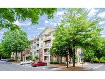 Condominium building with balconies, manicured landscaping, and parking at 1965 Nocturne Dr # 1306A, Alpharetta, GA 30009