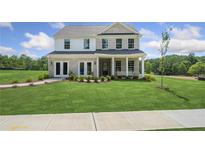 Beautiful two-story home featuring a manicured front lawn, brick facade, and welcoming front porch at 317 Foxglove Way, Mcdonough, GA 30253