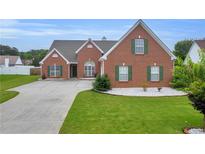 Charming brick home with manicured lawn and green shutters at 502 Stoneland Pl, Lawrenceville, GA 30046