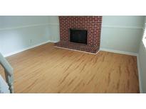 Open living room with hardwood floors and a brick fireplace ready for cozy evenings at 936 Glynn Oaks Dr, Clarkston, GA 30021