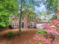 Charming two-story brick home featuring a well-manicured front yard with beautiful landscaping at 4365 Wicklow Ct, Suwanee, GA 30024