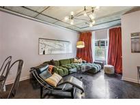 Chic living room featuring a plush green sofa, modern lighting, and exposed ductwork at 800 Peachtree Ne St # 1014, Atlanta, GA 30308