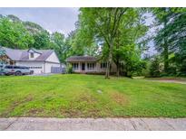 Charming single-story home with a welcoming front porch and a well-manicured lawn at 5310 Arrowind Nw Rd, Lilburn, GA 30047