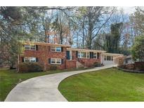 Charming brick home featuring a well-manicured lawn and a long driveway at 1415 Dalewood Ne Dr, Atlanta, GA 30329