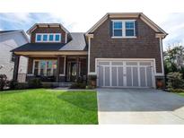 Charming two-story home featuring a well-manicured lawn, shingle siding, and an attached two-car garage at 322 Woodridge Pass, Canton, GA 30114