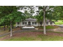 Charming brick home featuring a welcoming front porch and beautiful landscaping at 400 Simpson Ne Rd, White, GA 30184