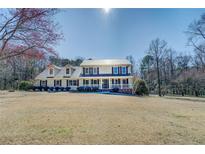 Inviting two-story home featuring a metal roof and a covered front porch at 1103 Wallington Nw Ct, Conyers, GA 30012