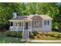 Charming home with a stone accent and a welcoming front porch in a serene, wooded setting at 187 Gilberts Way, Temple, GA 30179