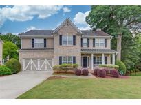 Charming two-story home with brick and siding, landscaped yard, and a two-car garage at 262 Sandhurst Ct, Suwanee, GA 30024