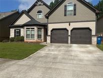Charming two-story home featuring a two-car garage, well-maintained lawn, and attractive stone accents at 1749 Misselthrush Ln, Mcdonough, GA 30253