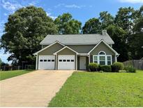 Charming home features a two-car garage, well-manicured lawn, and mature shade trees at 3722 Cherokee Overlook Dr, Canton, GA 30115