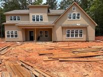 New two-story home featuring large windows and a covered front porch in a partially wooded lot at 7947 Post Rd, Winston, GA 30187
