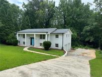 Charming two-story white brick home featuring a blue front door and well-manicured lawn at 1387 Renee Dr, Decatur, GA 30035