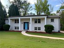 Charming brick home with a well-manicured lawn and a welcoming blue front door at 1387 Renee Dr, Decatur, GA 30035