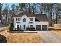 Charming two-story white brick home with a well-manicured lawn and a two-car garage at 3519 Wellsley Dr, Powder Springs, GA 30127