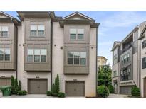 Beautiful townhome with a painted brick exterior, two car garage and manicured landscaping at 635 Broadview Ne Pl, Atlanta, GA 30324